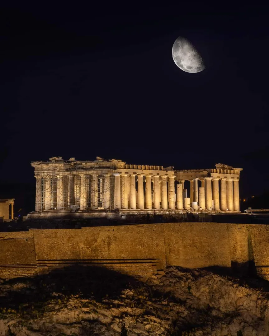 Parthenon iluminado à noite sob a lua, na Acrópole de Atenas